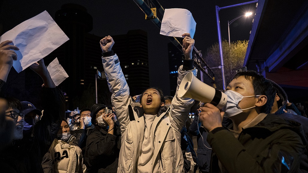 BEIJING, CHINA -NOVEMBER 28: Protesters shout slogans during a protest against Chinas strict zero COVID measures on November 28, 2022 in Beijing, China. Protesters took to the streets in multiple Chinese cities after a deadly apartment fire in Xinjiang province sparked a national outcry as many blamed COVID restrictions for the deaths. (Photo by Kevin Frayer/Getty Images)